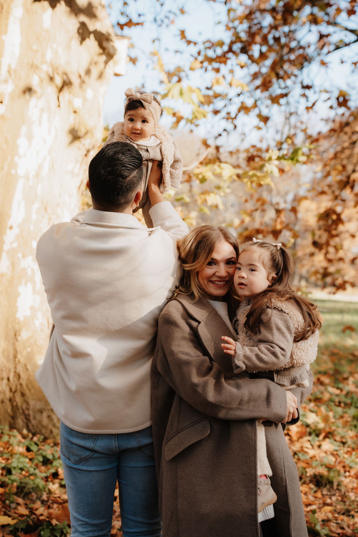 Familienshooting Herbst Brandenburg – Vater hält Kind hoch im Herbstlaub