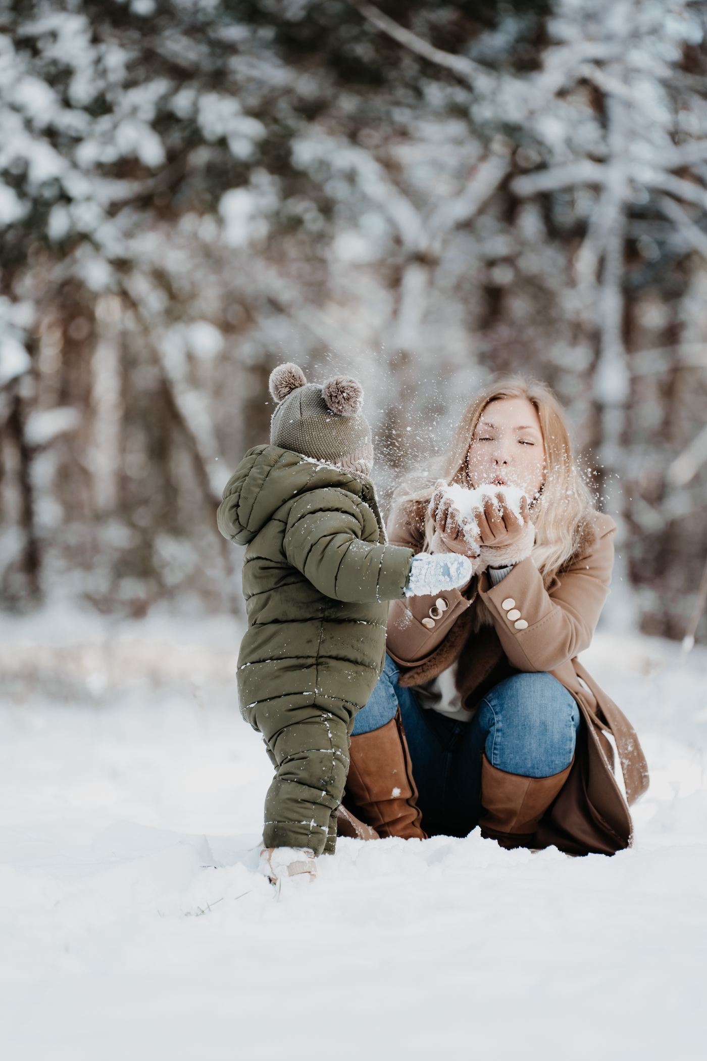 Familienfotograf Berlin – Mutter und Kind pusten Schnee im Winter