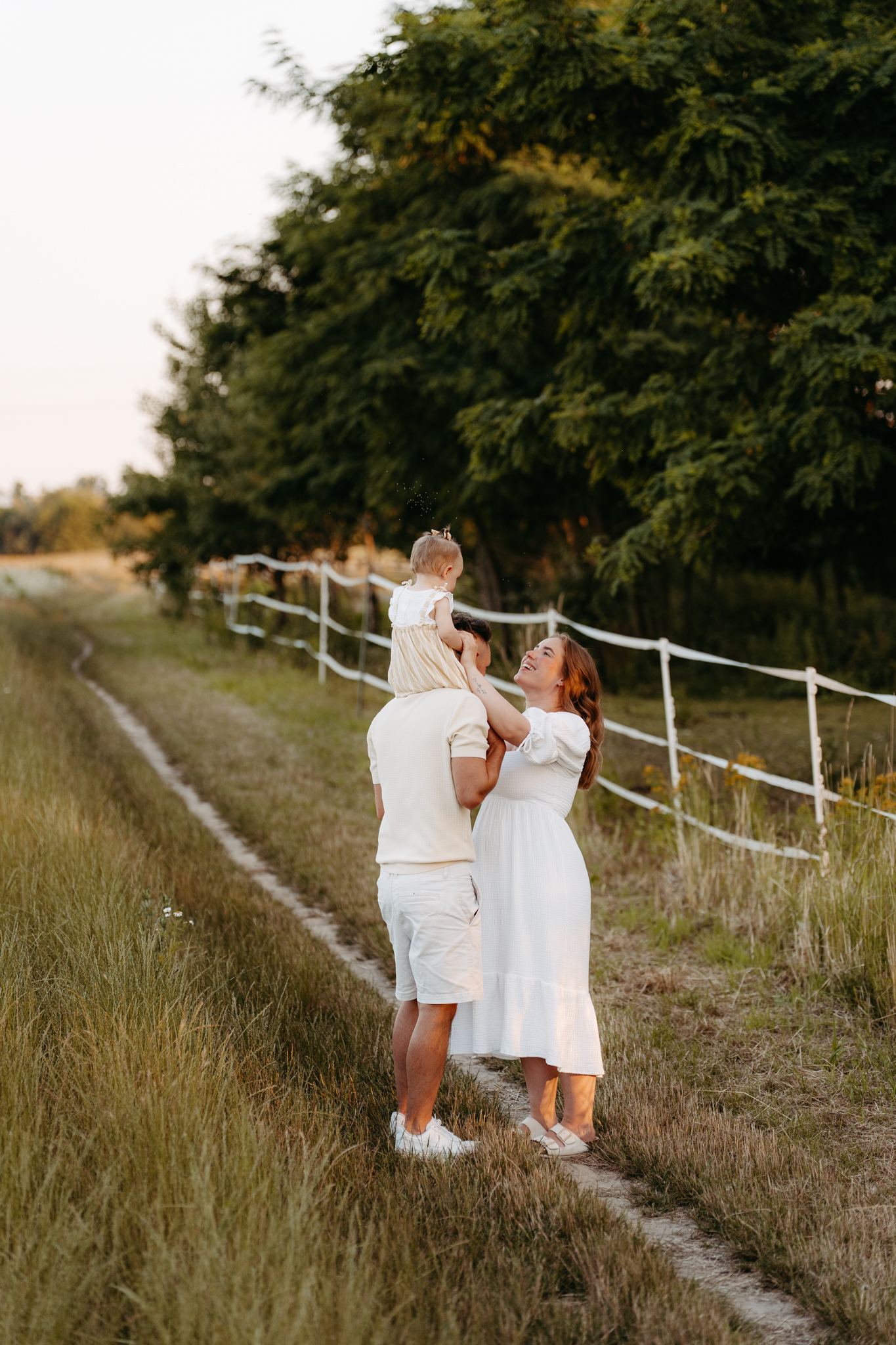 Outdoor Familienshooting Brandenburg – Vater mit Kind auf den Schultern im Sommerlicht